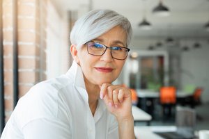 Older woman with grey hair styled in a soft pixie cut